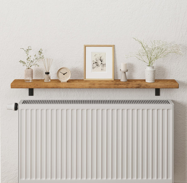 a wooden shelf mounted on a wall, displaying various decorative items such as a clock, a picture frame, a vase with flowers, and a small plant.
