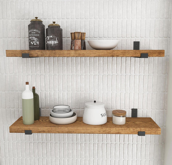 a set of wooden shelves mounted on a white brick wall, displaying various kitchen items such as bottles, bowls, and a teapot.