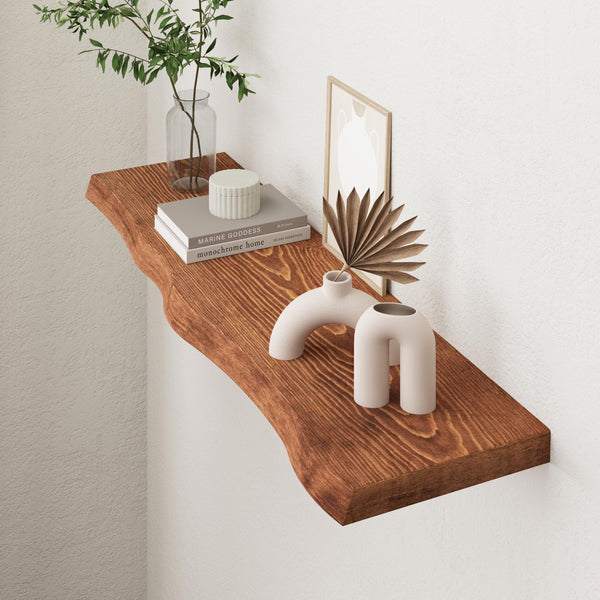 a wooden shelf with various decorative items on it, including a plant, books, and two white vases.