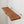 a wooden shelf mounted on a white wall.