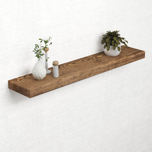 a wooden shelf mounted on a white brick wall, displaying a variety of decorative items, including a potted plant, a vase, and a small figurine.