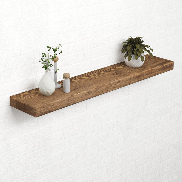a wooden shelf mounted on a white brick wall, displaying a variety of decorative items, including a potted plant, a vase, and a small figurine.