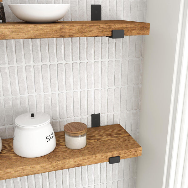 a set of wooden shelves with various items on them, including a white ceramic container, a wooden jar, and a white bowl. The shelves are set against a white brick wall, creating a clean and minimalist aesthetic.