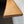a wooden shelf or ledge mounted on a wall, with a dark background.