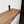 A wooden shelf mounted on a wall, with a black metal bracket attached to the wall.
