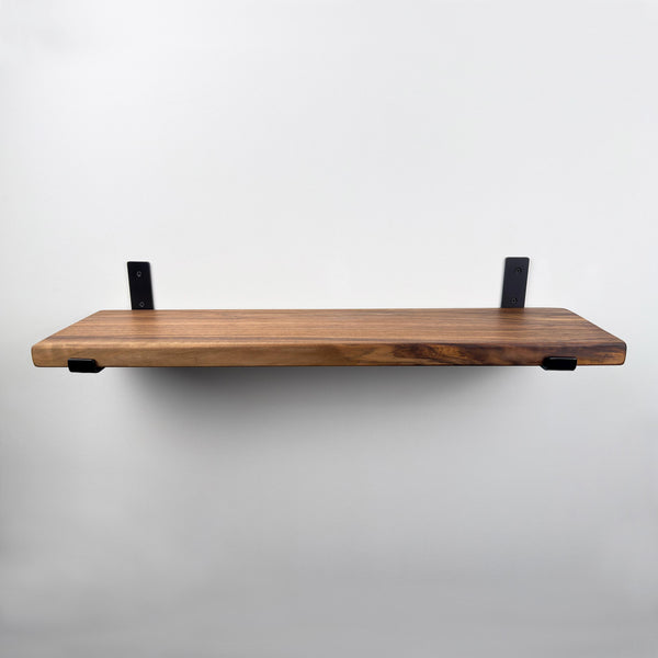 A simple, minimalist wooden shelf mounted on a white wall.