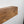a wooden shelf or board mounted on a wall, with a white background.