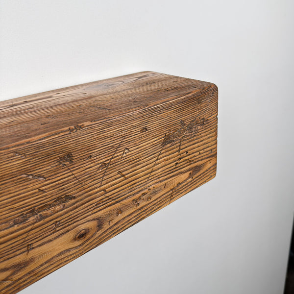 a wooden shelf or board mounted on a wall, with a white background.