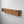A wooden shelf mounted on a white wall.