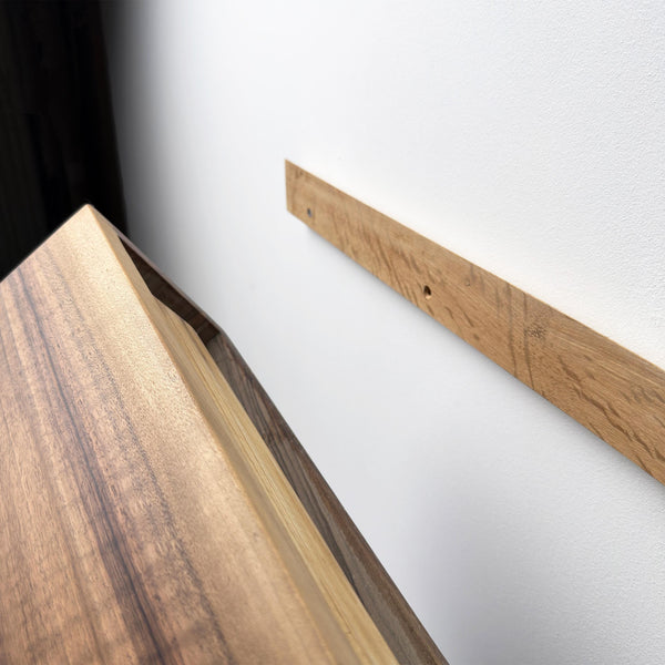 a wooden surface with a wooden board mounted on a white wall.