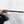 A person is using a power drill to drill a hole in a white wall.