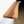 A wooden shelf mounted on a wall, with a natural wood grain texture and a small knot visible on the surface.