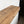 a wooden shelf or countertop with a natural wood grain pattern, placed against a white wall.