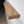 a wooden shelf mounted on a wall, with a dark brown, textured finish.