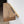 a wooden shelf mounted on a wall, with a dark-colored wooden plank and a light-colored wooden support beam.