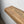 a wooden shelf or ledge with a natural wood grain texture, mounted on a white wall.